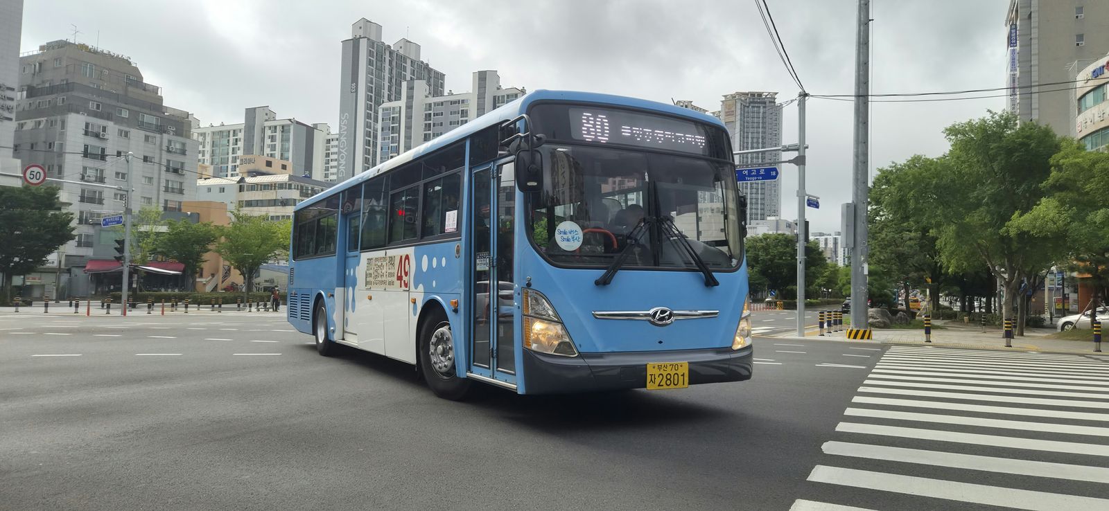 Blauwe stadsbus in Busan bij een kruispunt