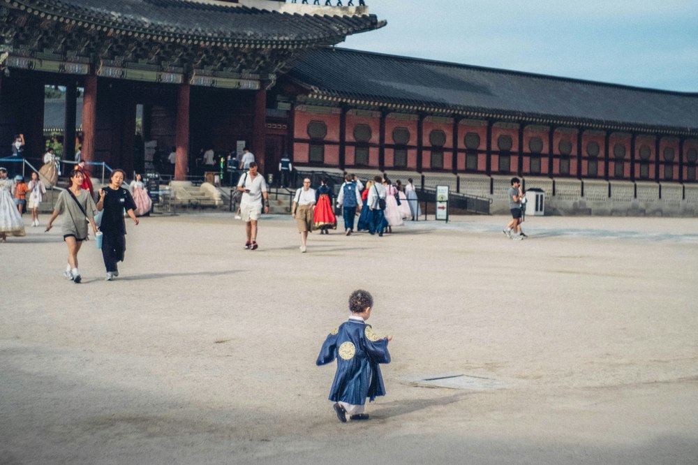 Kind in hanbok rent over het plein van Gyeongbokgung Palace in Seoul