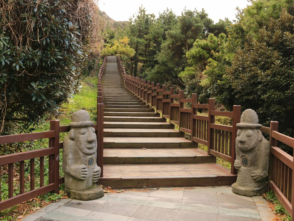 Houten trappenpad met dolharubang-beelden op Jeju