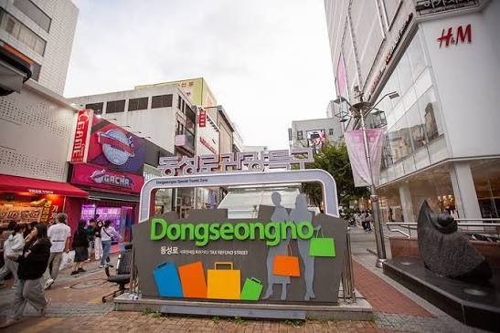 Bord van winkelstraat Dongseongno in Daegu met winkels en voorbijgangers