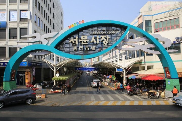 Overdekte straat van de Seomun-markt in Daegu met kleding en winkelende mensen