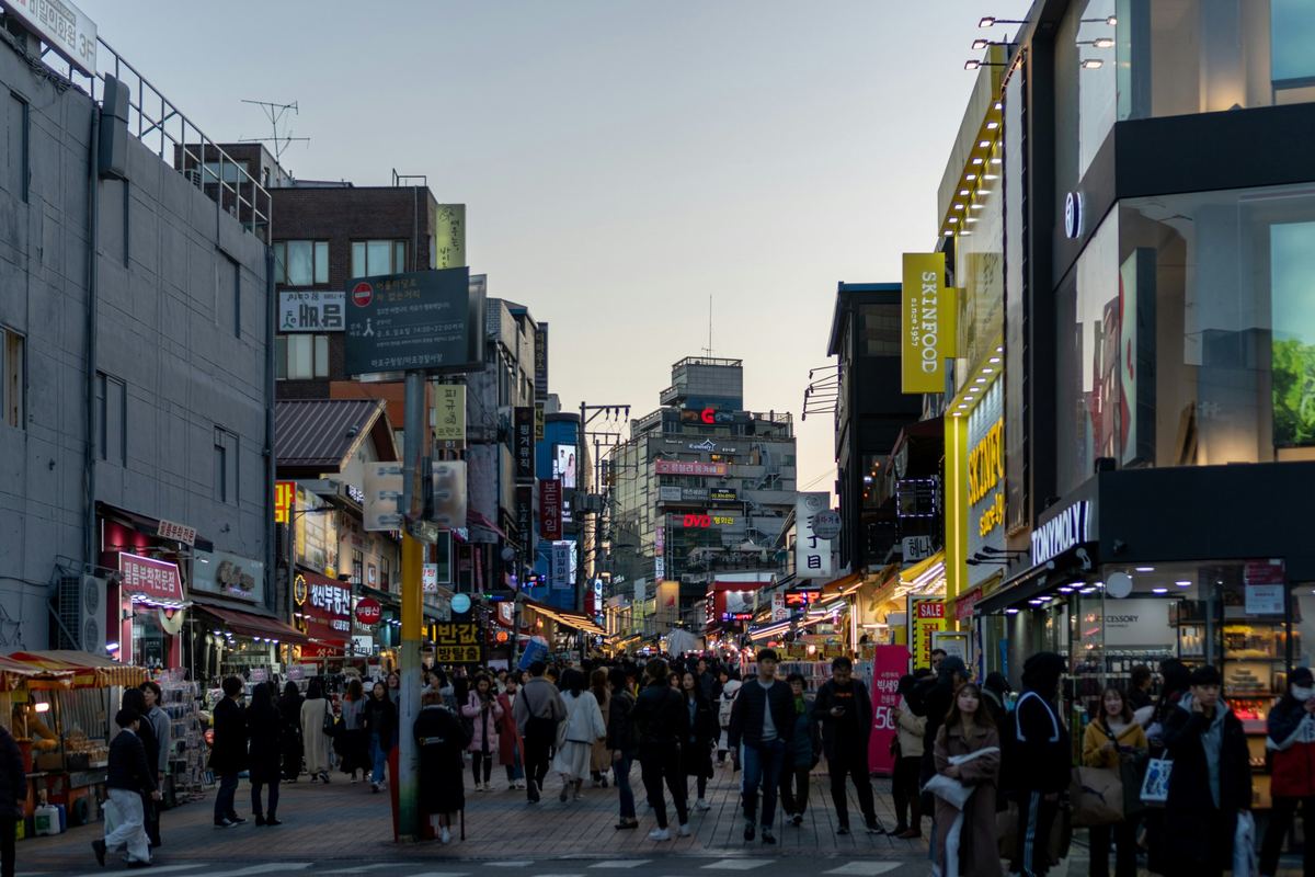 Hongdae in de avond met jongeren, neonreclames en straatmuzikanten