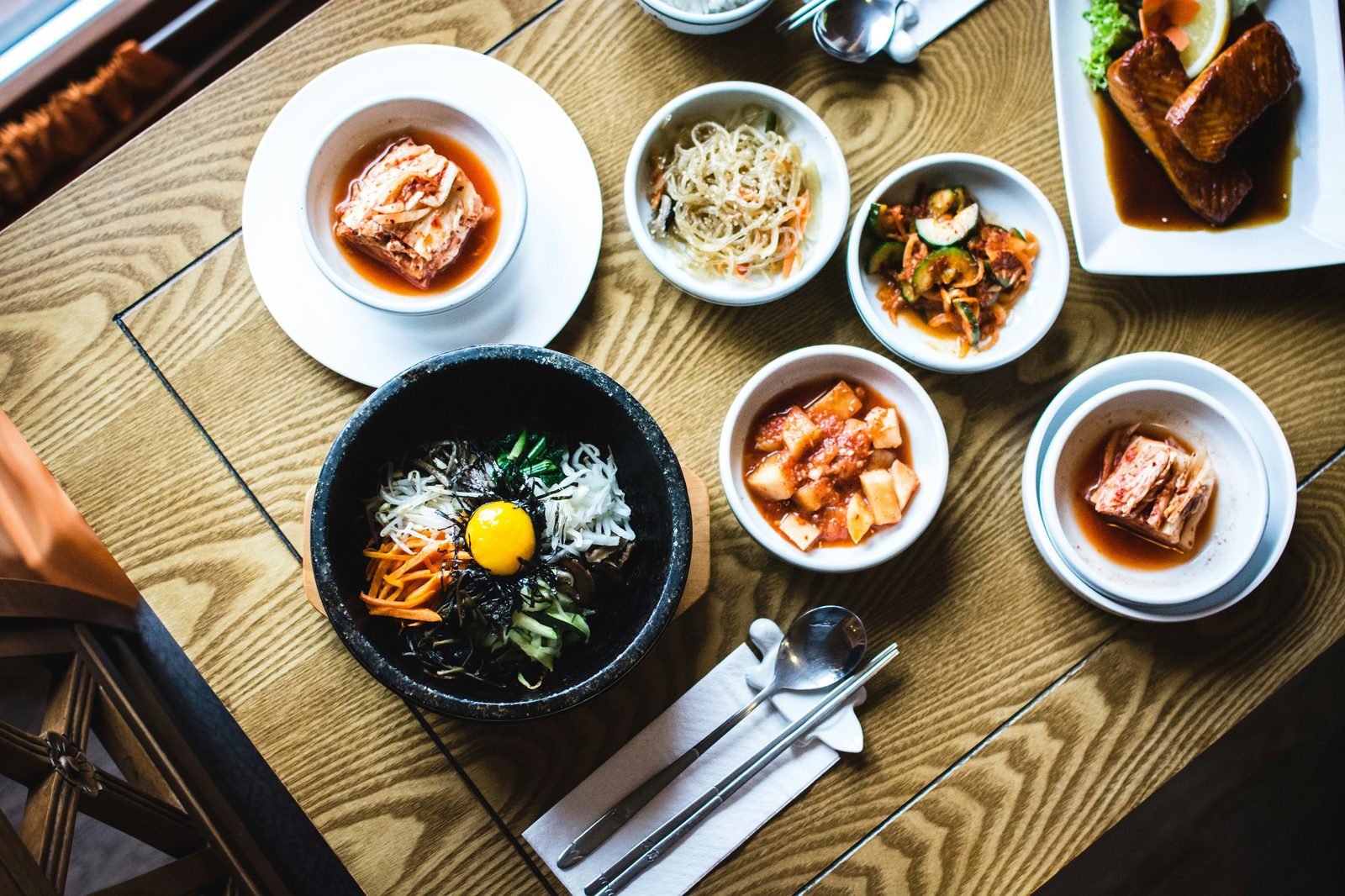 Bibimbap in een stenen kom met Koreaanse banchan bijgerechten